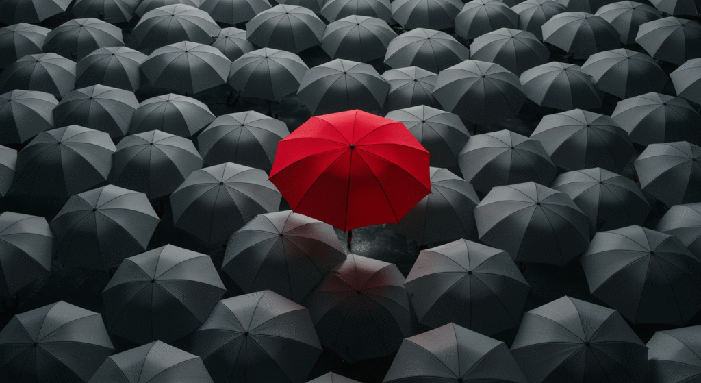 Red umbrella standing out from grey umbrellas